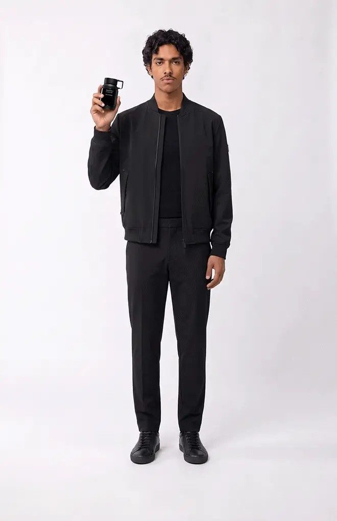 Model dressed in black presenting a fragrance